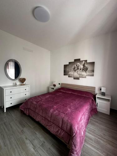 a bedroom with a large bed with a purple blanket at Sweet house Malpensa in Somma Lombardo