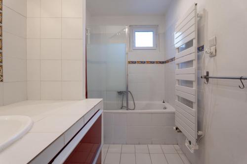y baño blanco con bañera, lavamanos y ducha. en Maison provençale, en Cornillon-Confoux