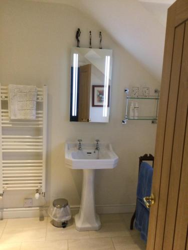 a bathroom with a sink and a mirror at Field End House in Cirencester