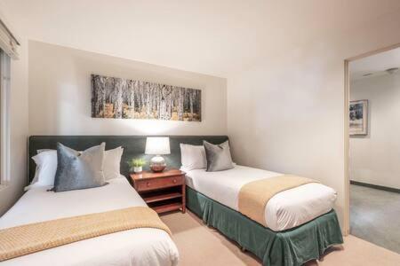 een slaapkamer met 2 bedden en een spiegel bij 2 BR 3BA Condo - AC, Heated Pool, Walk to Town in Aspen