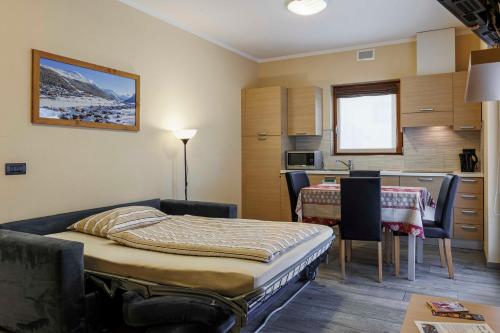 リヴィーニョにあるChalet Armonyのベッドとキッチン付きの小さな部屋
