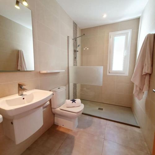 a bathroom with a toilet and a sink and a shower at Na Fonda Cala D'or in Cala d´Or