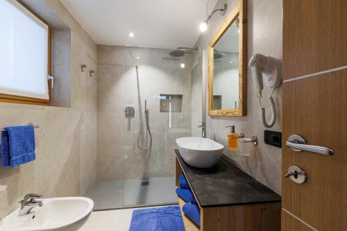 y baño con lavabo y ducha. en Chalets Molin en Livigno