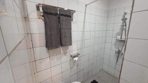 a bathroom with a shower with a toilet and a towel at Kartika Lodge in Bengkok