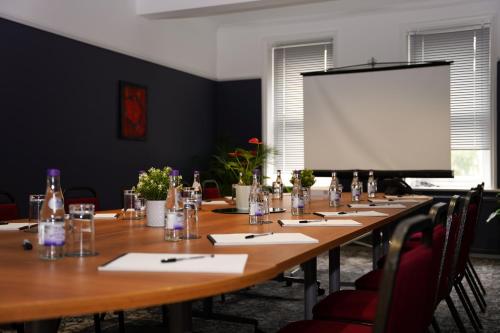 a long table in a room with a white screen at Hamlet Hotels Maidstone in Maidstone