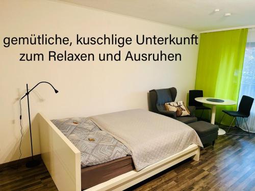 um quarto com uma cama e uma cadeira num quarto em Gaishöll-Wasserfälle Apartment Schwarzwald em Sasbachwalden