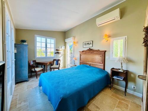 マンドリュー・ラ・ナプールにあるLe Clos des Vignesのベッドルーム(青いベッド1台、テーブル付)