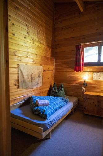 a bedroom with a bed in a wooden cabin at Chasa Avant Porta in Ramosch