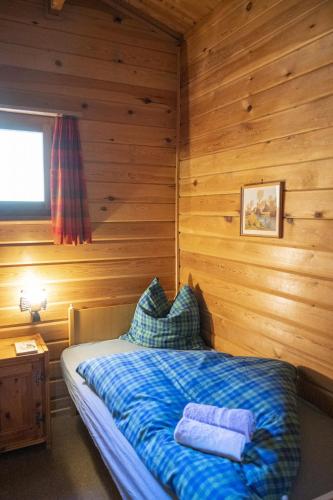 a bedroom with a bed in a wooden room at Chasa Avant Porta in Ramosch