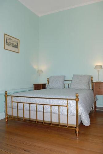 a bed in a room with two night stands and two lamps at Grand Appartement a Maison sculptée in Autun