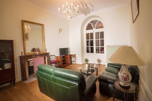 a living room with a green couch and a table at Grand Appartement a Maison sculptée in Autun