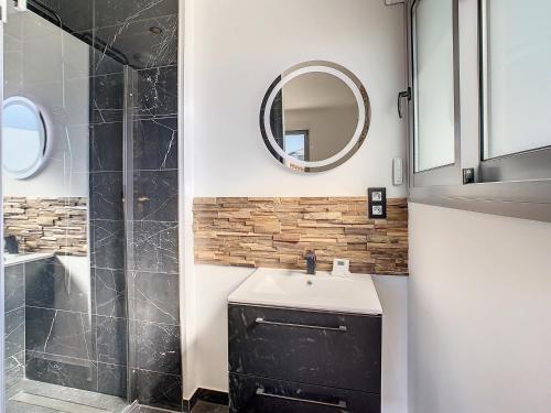 une salle de bain avec un lavabo et un miroir dans l'établissement Villa Heure Bleue, à Saint-Georges-de-Didonne