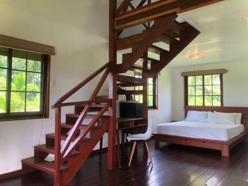 a bedroom with a bed and a spiral staircase at Plantage Resort Frederiksdorp in Paramaribo