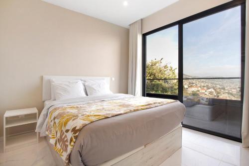 a bedroom with a bed and a large window at Dream View in Funchal