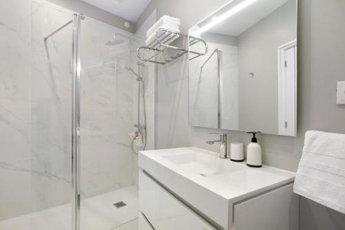 a white bathroom with a shower and a sink at Dream View in Funchal