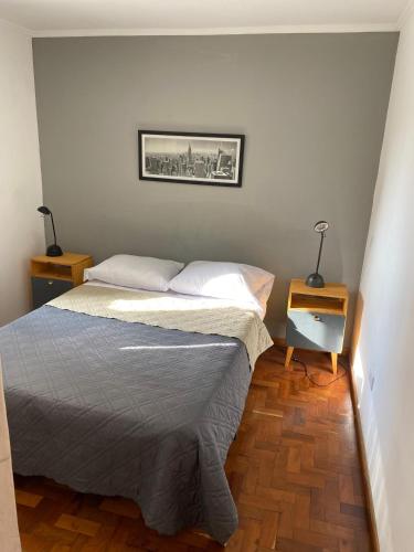 ein kleines Schlafzimmer mit einem Bett und zwei Nachttischen in der Unterkunft Cómodo departamento, excelente ubicacion in Cordoba