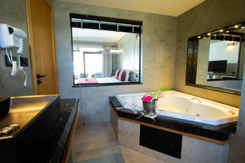 baño con bañera grande y espejo grande en Pousada da Torre, en Morro de São Paulo
