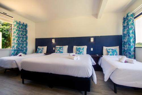 three beds in a room with blue walls and windows at Hotel Latitud Buzios by Latitud Hoteles in Búzios