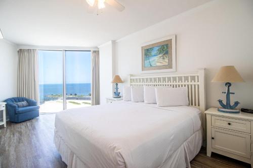 een witte slaapkamer met een bed en een groot raam bij Sea Breeze 908 in Biloxi
