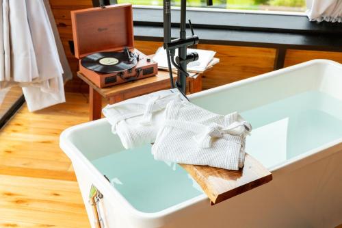 eine weiße Badewanne mit Handtüchern in der Unterkunft A Cabana mais aconchegante da Serra Catarinense in Urubici