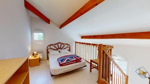 une petite chambre avec un lit et un escalier dans l'établissement Villa Aquatica Piscine & Plage, à Plage-des-Demoiselles