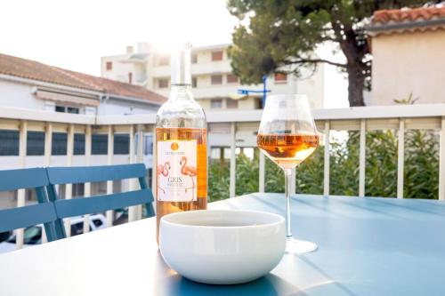 - une bouteille de vin et un verre de vin sur une table dans l'établissement Résidence Marie-Thérèse, au Grau-du-Roi