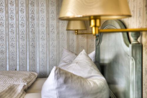 a bedroom with a bed with a lamp and pillows at Hotel am Markt Altentreptow in Altentreptow