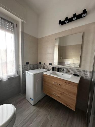 a bathroom with a sink and a toilet and a mirror at Sweet house Malpensa in Somma Lombardo
