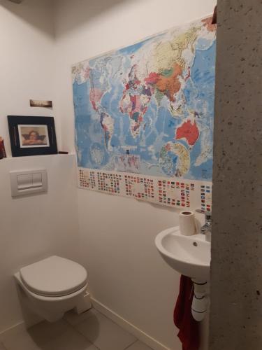 łazienka z toaletą i mapą na ścianie w obiekcie Kattalin enia w mieście Anglet