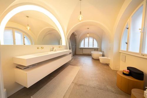 a bathroom with a large white sink and a tub at Elegante Jugendstilvilla in Vienna