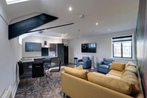 a living room with a yellow couch and a kitchen at Temple Court Cavern Quarter Apartments by Happy Days in Liverpool