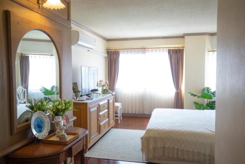 a bedroom with a bed and a sink and a mirror at Secret garden in Chiang Mai
