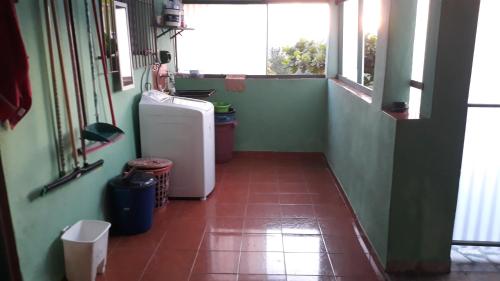 um pequeno quarto com um frigorífico e uma janela em Recanto de cachoeiras em Itariri