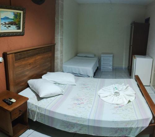 a bedroom with two beds and a dresser and a bed at Morada do Aventureiro in Angra dos Reis