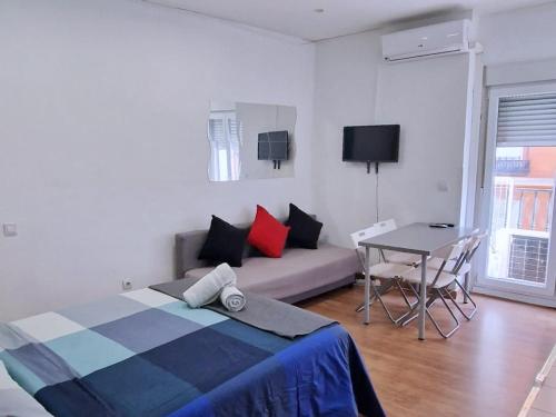 sypialnia z łóżkiem, stołem i kanapą w obiekcie Apartamentos EconoStay Barbieri 1 w Madrycie