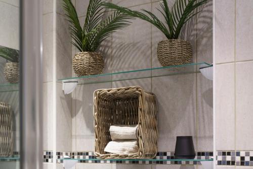 einen Korbstuhl in einem Bad mit zwei Pflanzen in der Unterkunft Nice Renting - FODERE - Charm & Comfort 2P Heart of Nice - AC & WiFi in Nizza