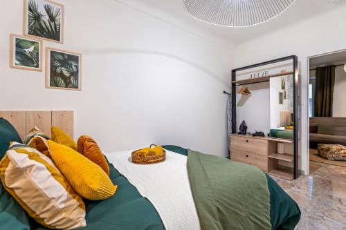 ein Schlafzimmer mit einem Bett mit gelben und grünen Kissen in der Unterkunft Nice Renting - FODERE - Charm & Comfort 2P Heart of Nice - AC & WiFi in Nizza