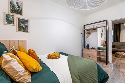 - une chambre dotée d'un lit avec des oreillers jaunes et verts dans l'établissement Nice Renting - FODERE - Charm & Comfort 2P Heart of Nice - AC & WiFi, à Nice