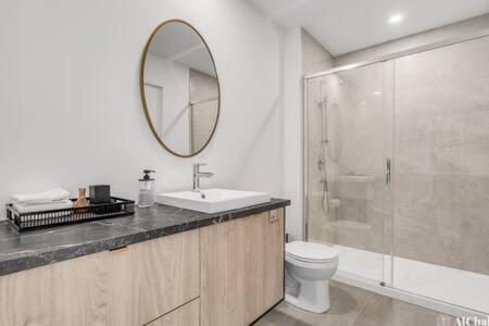a bathroom with a sink and a toilet and a mirror at BLOOM - Luxe et Confort en forêt in Valcartier Station