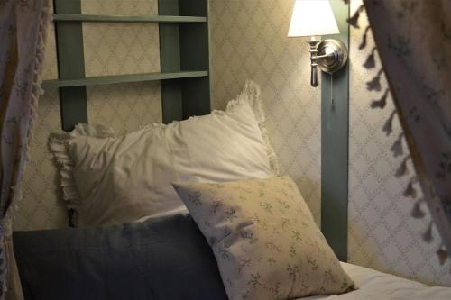 a bed with a pillow and a lamp and a shelf at Romantische Zeitreise in historischer Käserei in Unlingen