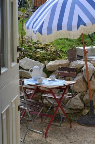 a table with a tea pot and an umbrella at Romantische Zeitreise in historischer Käserei in Unlingen
