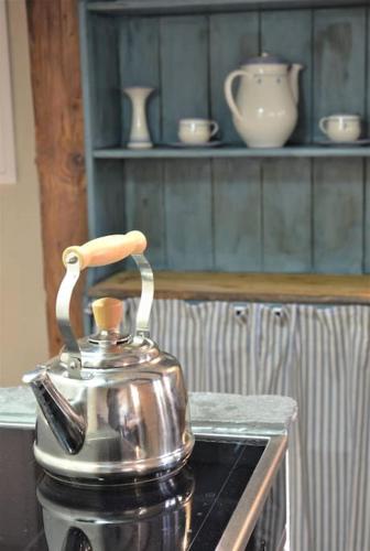 a tea kettle sitting on top of a stove at Romantische Zeitreise in historischer Käserei in Unlingen