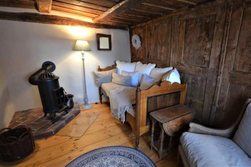 a living room with two beds and a woodburning stove at Romantische Zeitreise in historischer Käserei in Unlingen