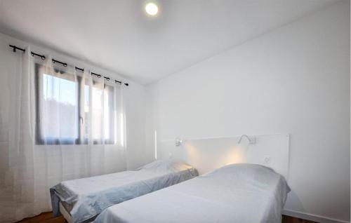 2 camas en una habitación blanca con ventana en Amazing Home In La Palme With Private Swimming Pool, Can Be Inside Or Outside, en Lapalme