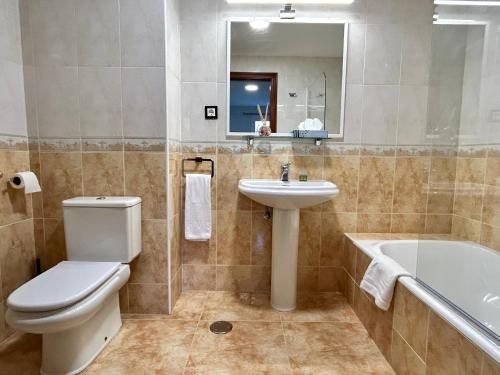 uma casa de banho com um WC, um lavatório e uma banheira em Bicis & Vacas em La Pola de Gordón