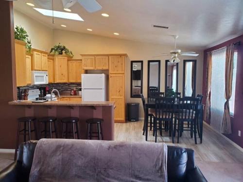 a kitchen with wooden cabinets and a bar with stools at I Deal Lake Powell Home 3BR, Jacuzzi, BBQ, Firepit in Page