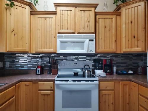 a kitchen with a white stove and a microwave at I Deal Lake Powell Home 3BR, Jacuzzi, BBQ, Firepit in Page