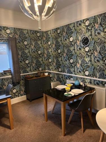 een eetkamer met een tafel en een muur met patronen bij Most Easterly Guest House in Pakefield