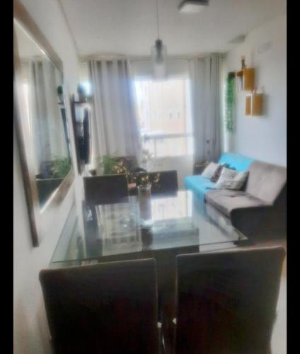 - un salon avec un canapé et une table en verre dans l'établissement Apartamento disponível 1 dormitório, à Tramandaí