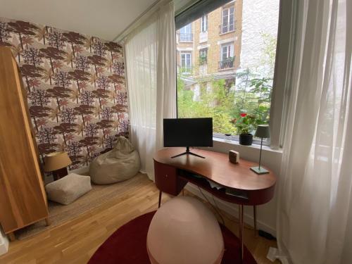 um quarto com uma secretária e uma janela com um computador em Maison de ville d'architecte parking gratuit em Paris